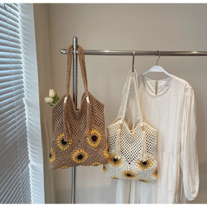 Close-up of handmade sunflower crochet tote bags with fringe and mesh hollow pattern