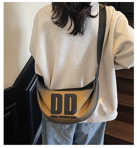Close-up of yellow and black gradient nylon crescent bag with DD letter print on model