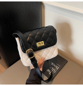 Detail of a contrasting quilted crossbody bag featuring a gold twist lock and a leather strap