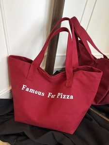 Borsa tote in tela rosso scuro con scritta Famous For Pizza e capienza generosa