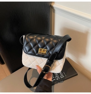 Detail of vintage bicolor crossbody bag featuring quilted texture and gold twist lock