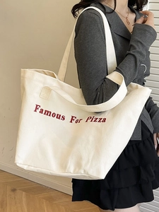 Borsa tote in tela crema con scritta rossa Famous For Pizza indossata da modella