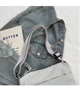 Dettaglio borsa a tracolla in nylon grigio chiaro con ampia tracolla regolabile su denim