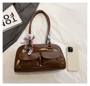 Detailed size comparison of the dark brown bowling shoulder bag with a smartphone