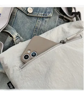 Dettaglio della tasca frontale con zip su borsa in nylon grigio con spazio per lo smartphone