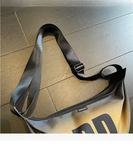 Detail of adjustable nylon shoulder strap and fashion label on gradient crossbody bag