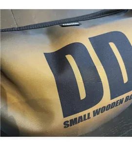 Close-up of golden brown twill fabric with black printed logo and fashion label detail