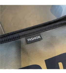 Macro shot of the black FASHION woven label on grey nylon fabric with golden texture
