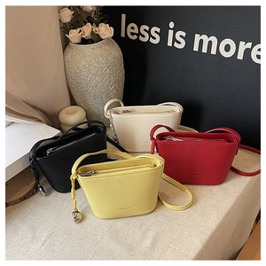 Litchi pattern leather bucket bags in black, cream, red, and yellow with silver zippers