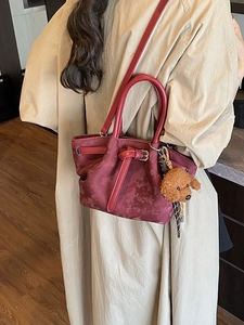 Sac seau bordeaux texturé avec charme ours en peluche montré de vue latérale
