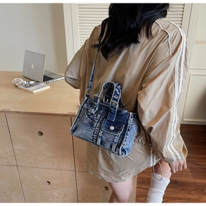 Rear view of a model carrying a vintage washed denim tote bag in a cozy indoor setting
