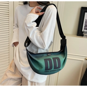 Detail of gradient nylon crescent bag showing DD print and wide black shoulder strap