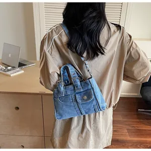 Classic blue denim tote bag shown as a crossbody in a modern lifestyle office setting