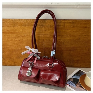 Detail of dark red vintage bowling bag with lace bow charm and heart metal pendant