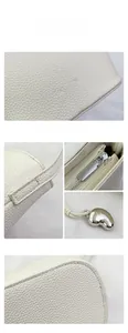 Detail of white lychee texture leather bag with FASHION emboss and silver hardware