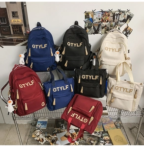 Detail of school backpacks and tote bags in navy, black, cream, and burgundy with duck charms