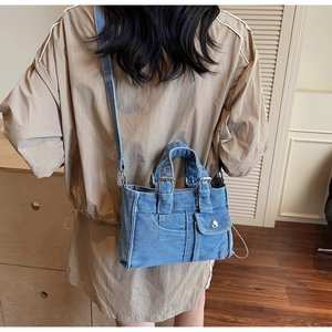 Blue denim mini tote bag detail showing dual handles and adjustable shoulder strap styling