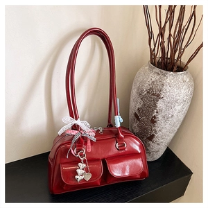Close-up of red patent leather bowling bag with lace bows and heart charms