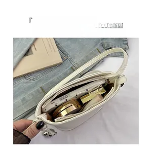 Internal view of the white pebble leather bag showing storage for phone and cosmetics