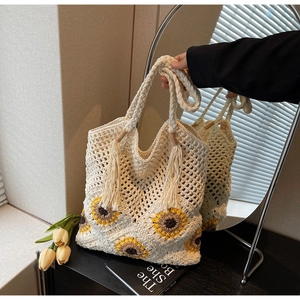 Detail of handmade crochet sunflower tote bag with woven handles and tassels