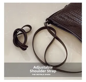 Detailed view of the dark brown woven leather bucket bag with an adjustable shoulder strap