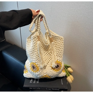 Close-up of handmade crochet sunflower tote bag with tassels and woven mesh texture