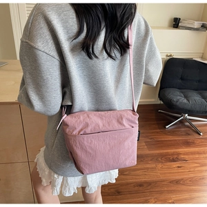 Vue arrière d'un mannequin portant un sac seau minimaliste rose lotus en nylon