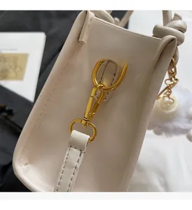 Gros plan du fermoir doré et de la texture en cuir blanc d'un sac à main élégant