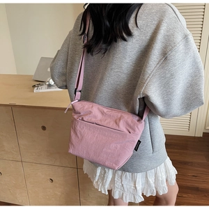Détails du sac seau rose en nylon avec bandoulière réglable et poche frontale