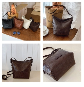 Detail of woven bucket bags in four colors with leather logo patch and slim strap