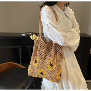 Detail of sunflower straw bag featuring handmade crochet pattern and tassel accents