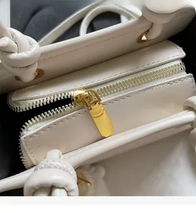 Gros plan de la fermeture éclair dorée et de la texture cuir d'un sac beige