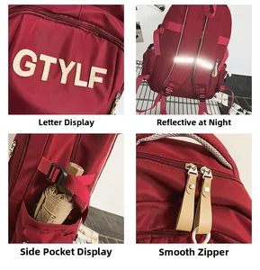 Detail view of red school backpack showing reflective strip, side pocket and metal zippers