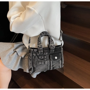 Detailed shot of dark gray washed denim handbag with cargo-style pockets and silver buckles