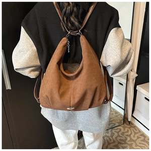 Detail of vintage brown suede backpack showing the curved silhouette and leather straps