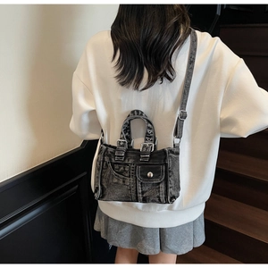 Back view of model wearing a vintage washed denim motorcycle crossbody bag in black