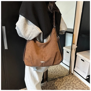 Brown suede hobo bag on a model showing large capacity and natural drape effect