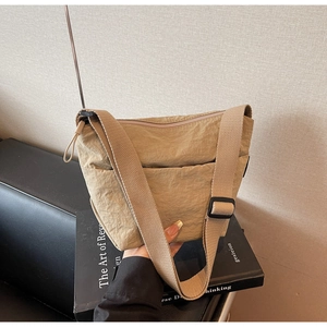 Détail d'un sac seau en nylon kaki montrant la texture et la sangle ajustable