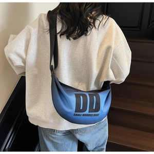 Blue gradient nylon crescent bag worn crossbody, showing sporty casual style and print