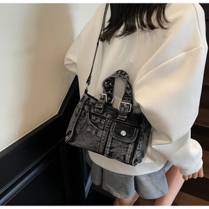 Close-up of vintage denim handbag with washed grey fabric and metal buckle details