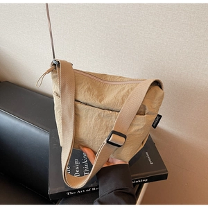 Dettaglio della borsa a tracolla in nylon kaki con trama stropicciata e tracolla in tessuto