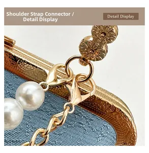 Detail view of gold embossed metal frame, light blue fabric, and white pearl chain strap