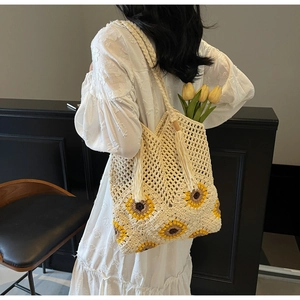 Detailed view of the large sunflower straw bag with long tassels and woven shoulder strap