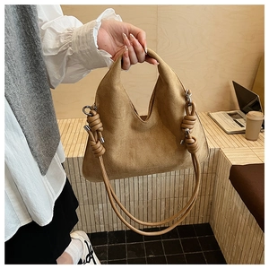 Detail of khaki frosted leather crossbody bag with knot shoulder strap and silver ring