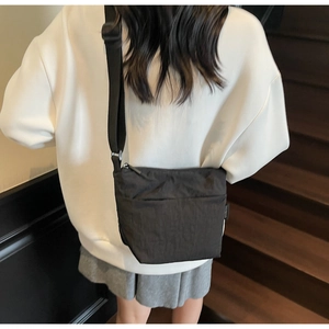 Détail du sac seau en nylon noir avec texture souple et bandoulière réglable