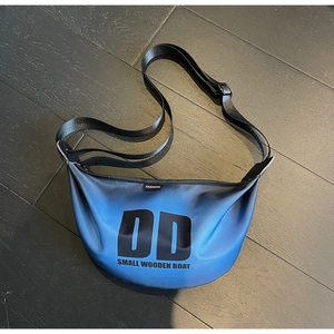 Close-up of a gradient blue nylon crossbody bag with DD logo and waterproof finish