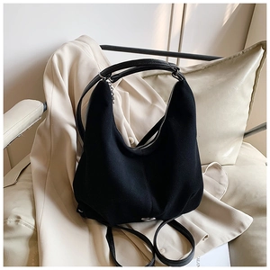 Detail of minimalist black felt tote bag with leather straps and silver metal hardware