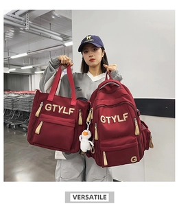 Close-up of red nylon backpack and tote bag set with GTYLF embroidery and duck charm