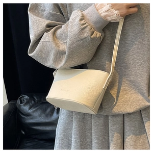 Detail of off-white bucket bag featuring lychee grain texture and fashion embossing