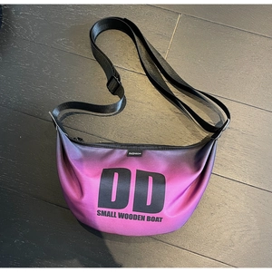 Detail of purple gradient crescent bag with DD print and adjustable nylon strap